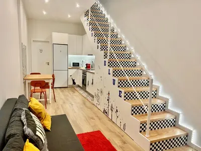 a staircase in a room with a couch and a table at Oporto Blue Boavista - Deluxe City Center Duplex in Porto