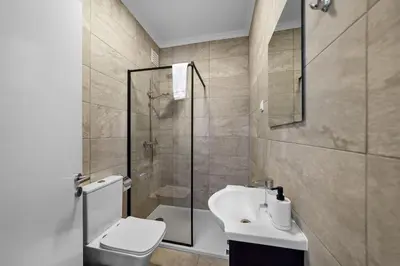 a bathroom with a toilet and a sink and a shower at Apartamento D' Alegria in Porto