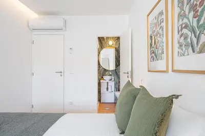 a bedroom with a white bed and a mirror at GuestReady - Relaxing moment in a vibrant city in Porto
