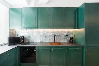 a green kitchen with green cabinets and a sink at GuestReady - Relaxing moment in a vibrant city in Porto
