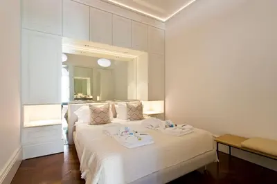 a white bedroom with a bed with towels on it at Boutique Rentals- THE CLéRiGoS Apt w/ patio in Porto