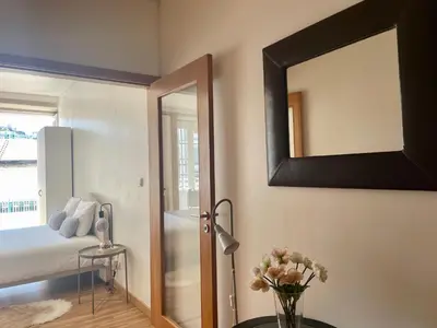 a bedroom with a mirror and a vase of flowers at Douro River Cozy Flats in Porto
