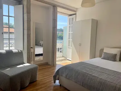 a bedroom with a bed and a view of a balcony at Douro River Cozy Flats in Porto