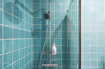 a shower in a blue tiled bathroom with a blow dryer at GuestReady - Porto's Charming Escape in Porto