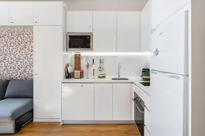 a kitchen with white cabinets and a refrigerator at GuestReady - Porto's Charming Escape in Porto