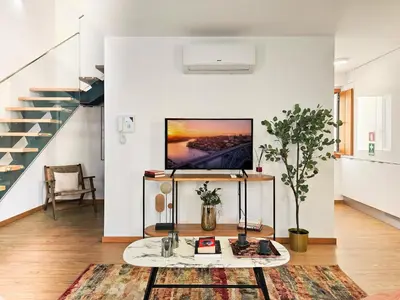 a living room with a tv on a wall at VIVA Boho House Duplex in Porto