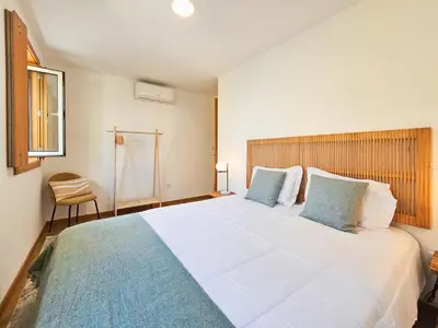 a bedroom with a large white bed with blue pillows at VIVA Boho House Duplex in Porto