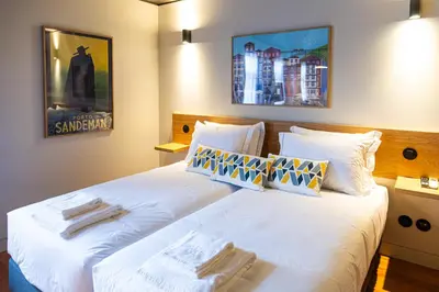a hotel room with two beds with towels on them at Fervença Suites in Vila Nova de Gaia