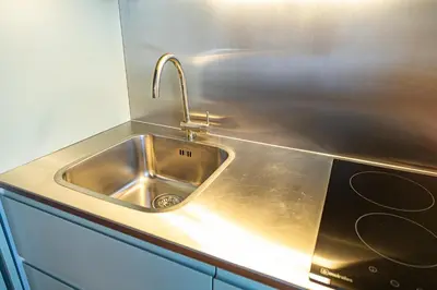 a stainless steel kitchen sink with a faucet at Fervença Suites in Vila Nova de Gaia