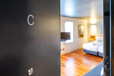 a door to a room with a bed and a bedroom at Fervença Suites in Vila Nova de Gaia