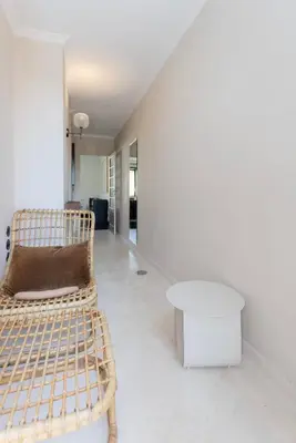 a white room with a rattan chair and a table at Liiiving in Porto - Casa Duque Apartments in Porto