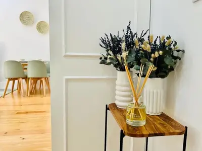 a vase with flowers on a table in a room at The Green House - Oporto Charming Apartment in Porto