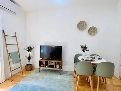 a living room with a table and a tv at The Green House - Oporto Charming Apartment in Porto