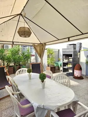 a white table and chairs in a patio with a fireplace at Porto Central Terrace Apartment in Porto