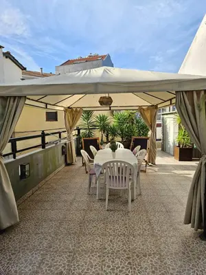 a table and chairs under a large umbrella on a patio at Porto Central Terrace Apartment in Porto