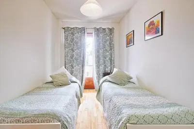 a bedroom with a bed and a dresser and a window at Camarão Apartment in Porto