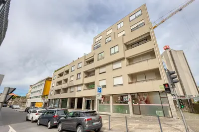 a tall building with cars parked in front of it at OPORTO GUEST Lobo Flat with Parking in Porto