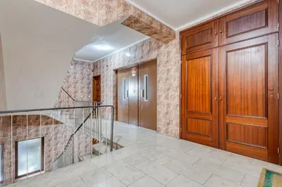 a hallway with a staircase and wooden doors at OPORTO GUEST Lobo Flat with Parking in Porto