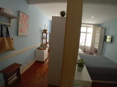 a room with a bedroom with a bed and a desk at Oupas 2 Lofts in Porto