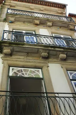 a building with a window and a balcony at Oupas 2 Lofts in Porto