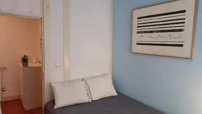 a room with a pillow and a picture on the wall at Oupas 2 Lofts in Porto