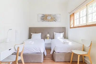 two beds in a room with a desk and chairs at The Porto Villa in Porto