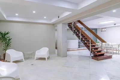 a lobby with a staircase and white chairs and tables at The Porto Villa in Porto