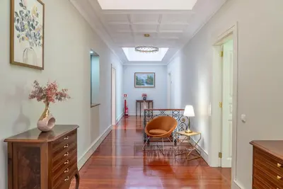 a hallway with a chair and a table in a room at The Porto Villa in Porto