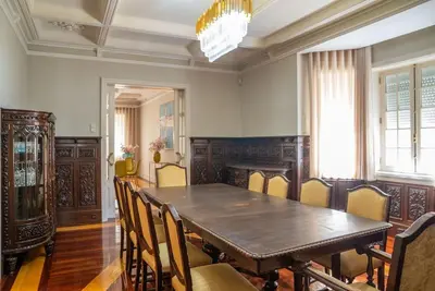 a dining room with a wooden table and chairs at The Porto Villa in Porto