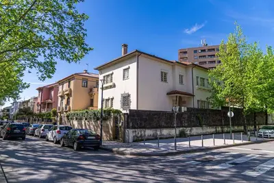 a street with cars parked in front of buildings at The Porto Villa in Porto