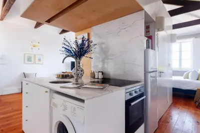 a white kitchen with a washer and dryer at Stylish Loft in the city centre in Porto