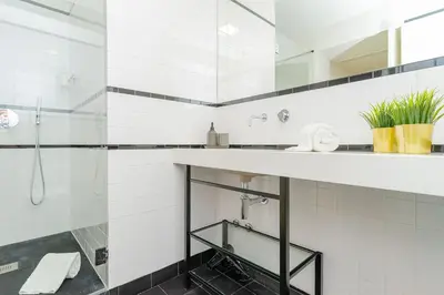 a white bathroom with a sink and a shower at Charming Apartment • Porto in Porto