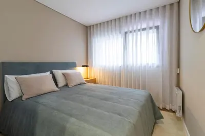 a bedroom with a large bed and a window at T2 Constituição in Porto