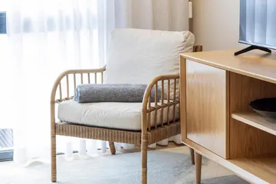 a wooden chair with a pillow on it in front of a window at T2 Constituição in Porto
