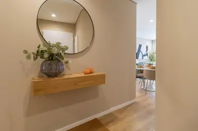 a mirror on a wall with a vase on a shelf at T2 Constituição in Porto
