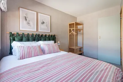 a bedroom with a large bed with a striped blanket at Trendy & Charming Apartment • Porto city center in Porto