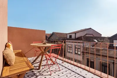 a balcony with a table and chairs on a building at Trendy & Charming Apartment • Porto city center in Porto