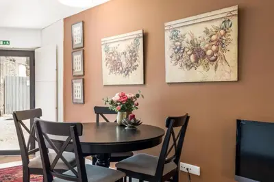 a dining room with a table and chairs and paintings on the wall at Cute 1-bedroom next to Douro River in Porto