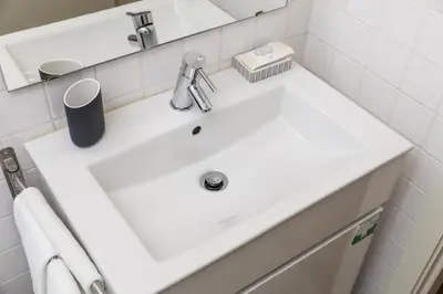 a white sink in a bathroom with a mirror at Cute 1-bedroom next to Douro River in Porto