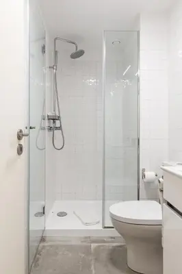 a white bathroom with a shower and a toilet at Cute 1-bedroom next to Douro River in Porto