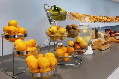 a display of oranges and other fruits in bowls on a counter at B&B HOTEL Porto Gaia in Vila Nova de Gaia