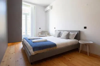 a bedroom with a bed with a blue blanket on it at Dream on - Flow in Porto