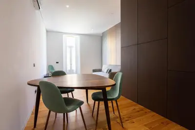 a dining room with a wooden table and green chairs at Dream on - Flow in Porto