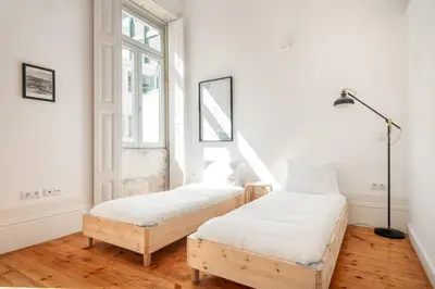 two beds in a room with two windows at Santa Catarina Studio Apartments in Porto