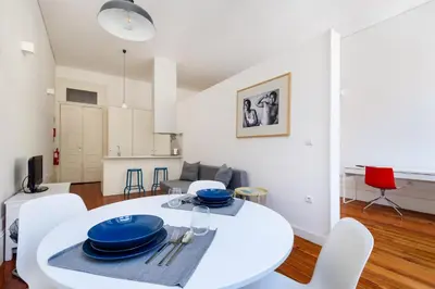 a white dining room with a white table and chairs at Santa Catarina Studio Apartments in Porto