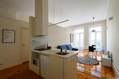 a kitchen with a sink and a living room at Santa Catarina Studio Apartments in Porto