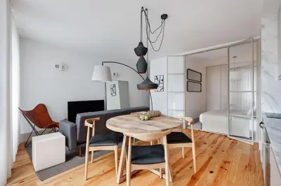a dining room and living room with a table and chairs at Stylish apartment in city center in Porto