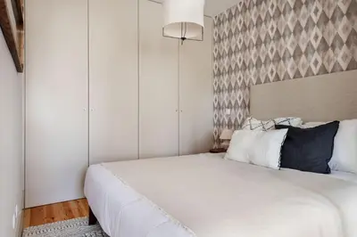 a bedroom with a large white bed with a headboard at Stylish apartment in city center in Porto