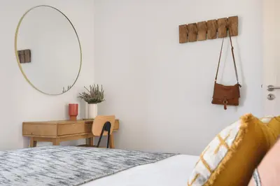 a bedroom with a bed and a desk with a mirror at Lovely 2-bed in the city centre with a sunny balcony in Porto