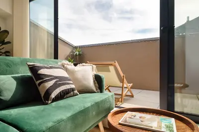 a living room with a green couch and a table at Lovely 2-bed in the city centre with a sunny balcony in Porto
